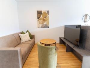 a living room with a couch and a tv at Apartment be calm by Interhome in Mieming