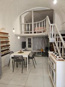 a living room with a table and a loft bed at CASA DI MAGGIE in Sanremo