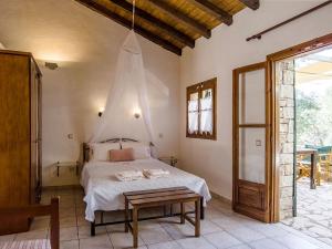 1 dormitorio con 1 cama con mosquitera encima en Adamantia Traditional Village en Bogdanátika