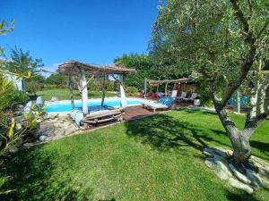 einen Hinterhof mit einem Pool mit Pavillon in der Unterkunft Maison climatisée en campagne, terrasses couvertes grand jardin ombragé et piscine in Aix-en-Provence