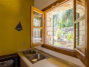 uma cozinha com um lavatório e uma janela em Adamantia Traditional Village em Bogdanátika