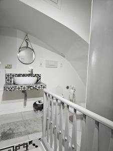a white bathroom with a sink and a staircase at CASA DI MAGGIE in Sanremo