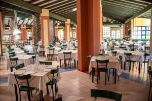 a banquet hall with white tables and chairs at VOI Vila do Farol Resort in Santa Maria