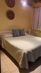 sypialnia z białym łóżkiem z 2 poduszkami w obiekcie Affitti brevi Tzia Licca w mieście Teulada