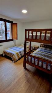 Un dormitorio con dos literas y una ventana. en Los Tres Mallos, en Islallana