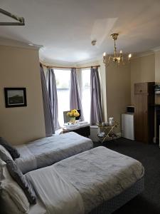 a bedroom with two beds and a window at Rose Marie Guest House in Peterborough