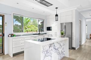 a white kitchen with marble counter tops at Humble Abode in Charlestown