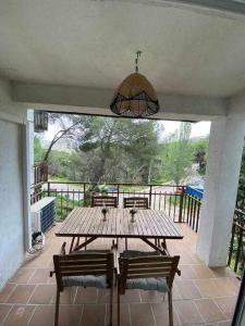 una mesa de madera y 2 sillas en el patio en Primera linea Pantano de San Juan para 6 personas, en San Martín de Valdeiglesias