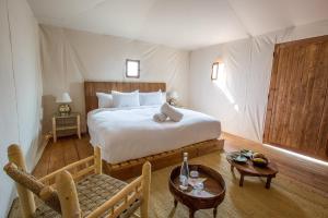 1 dormitorio con 1 cama grande y 1 mesa en The White Camel, en Marrakech