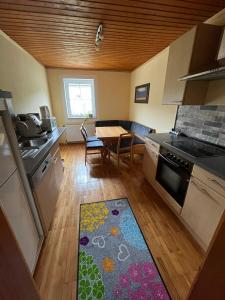 eine Küche mit einem Tisch und einem Küchenteppich in der Unterkunft Gästehaus Dürnberger in Molln