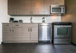 a kitchen with stainless steel appliances and wooden cabinets at Stylish 3BR Apartment At Midtown East in New York