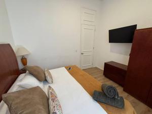 Casa 9 Esquinas - Granada في غواذالاخارا: غرفة نوم بسرير كبير وتلفزيون