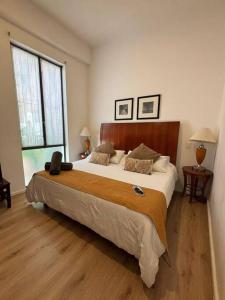 Casa 9 Esquinas - Granada في غواذالاخارا: غرفة نوم بسرير كبير ونافذة كبيرة