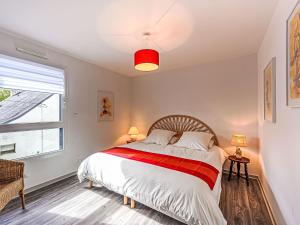 a bedroom with a bed with a red and white blanket at Holiday Home Maison Ker Anna by Interhome in Le Bono