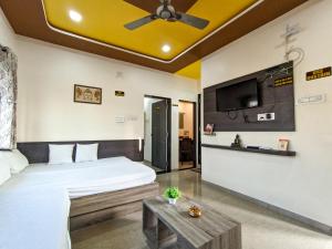 a bedroom with a bed and a tv and a table at Rudra Premium 1 BHK Fully AC in Garudeshwar
