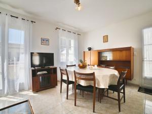a dining room with a table and chairs and a tv at Holiday Home Althea by Interhome in Saint-Pierre-dʼOléron +19 photos
