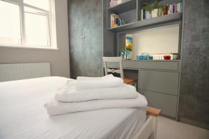 a bedroom with a bed with white towels on it at Spacious Double Room with Private Bathroom in Streatham Common, Southwest London in Streatham Vale