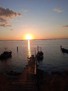 a dock with boats in the water at sunset at Casa Cicolani in Scardovari