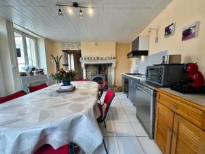 a kitchen with a table and a kitchen with a fireplace at Le Val Thibaud in Buncey +13 photos