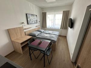 Habitación pequeña con cama y mesa en Penzion Raketa Bowling, en Opava