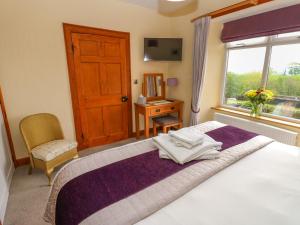 1 dormitorio con 1 cama con ventana y silla en Longwell House, en Grayrigg