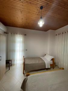a bedroom with two beds and a wooden ceiling at Rent Rooms Sakolli in Berat