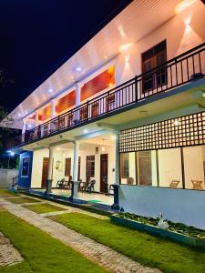 Un grand bâtiment blanc avec balcon est disponible la nuit. dans l'établissement Geethani Tourist Home Polonnaruwa, à Polonnâruvâ