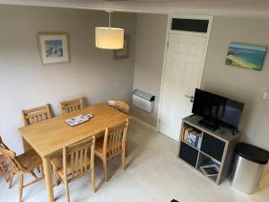 a living room with a wooden table and a television at Claire’s place in Hayle +6 photos