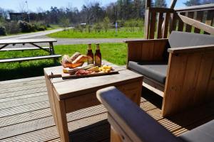a table with bottles of beer and bread on a deck at Luxe en romantische overnachting voor 2 in Behelp