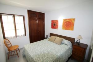 Un dormitorio con una cama y una silla y una ventana. en Casas Blancas 26, en Miami Platja 24 fotos más