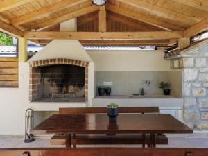 une cuisine extérieure avec une table en bois et une cheminée dans l'établissement Holiday Home Kristina by Interhome, à Pula
