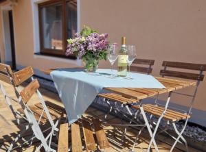 a table with a vase of flowers and wine glasses at Ferienwohnung beim Binder in Grabenstätt