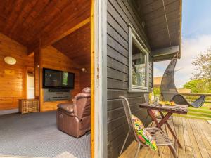 eine Veranda einer Hütte mit einem Tisch und Stühlen in der Unterkunft Chalet Chestnut Hot Tub Lodge by Interhome in Launceston + 46 Fotos