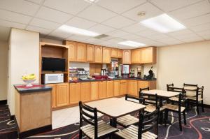 a kitchen and dining room with wooden cabinets and tables at Travelodge by Wyndham Sturgis in Sturgis