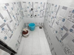 a bathroom with a blue bucket in the corner at Infinity Luxury Homestay in Garudeshwar