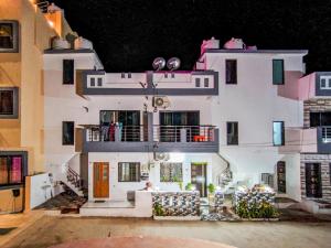 a large white building with a balcony at night at Infinity Luxury Homestay in Garudeshwar