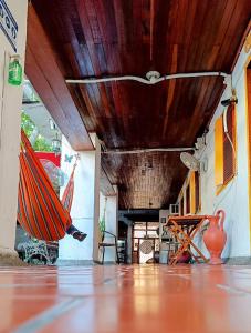 a room with a wooden ceiling and a table and surfboards at Hotel Nueva Granada in Santa Marta