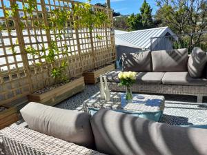 eine Terrasse mit Sofas, einem Tisch und einem Zaun in der Unterkunft Safari Villa Botique Hotel in Windhoek