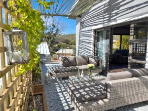 eine Terrasse mit Sofas und einem Tisch in der Unterkunft Safari Villa Botique Hotel in Windhoek