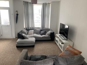 a living room with a couch and a tv at Double Room With Gym Access in Portsmouth