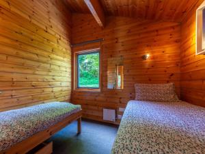 ローンセストンにあるChalet Bramley Hot Tub Lodge by Interhomeの丸太小屋のベッドが2つある寝室