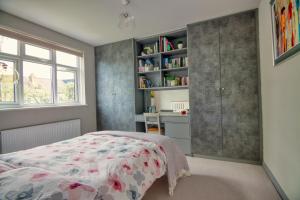 a bedroom with a bed and a book shelf at Spacious Double Room with Private Bathroom in Streatham Common, Southwest London in Streatham Vale