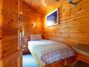 ローンセストンにあるChalet Bramley Hot Tub Lodge by Interhomeの木造キャビン内のベッド1台が備わるベッドルーム1室を利用します。 +39枚の写真