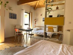 1 dormitorio con 1 cama, mesa y sillas en Les Cabanons, en Dardilly