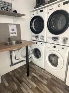 two washing machines and a sink in a laundry room at Appartement Tremblay en France in Tremblay En France