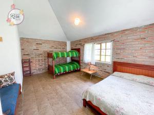 a bedroom with a bed and a brick wall at Santa Rosa de Lima Hostal Zuleta in Zuleta