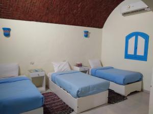 a room with two beds with blue sheets at malindy KA ماليندى كا in Aswan