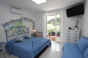 a bedroom with a blue bed and a balcony at Jungle Rooms in Cetara