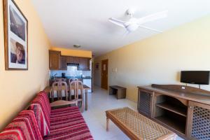 a living room with a couch and a kitchen at Complejo Las Tres Palmeras in Valle Gran Rey