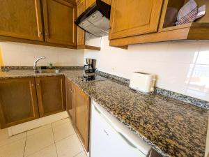 a kitchen with wooden cabinets and a counter top at CT Las Tres Palmeras in Valle Gran Rey